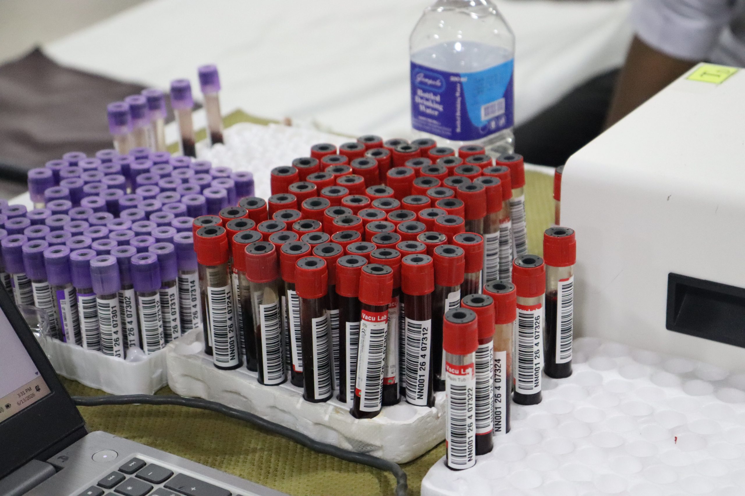 Blood sample vials organized in racks for health screening at Vimukthi Foundation blood donation camp